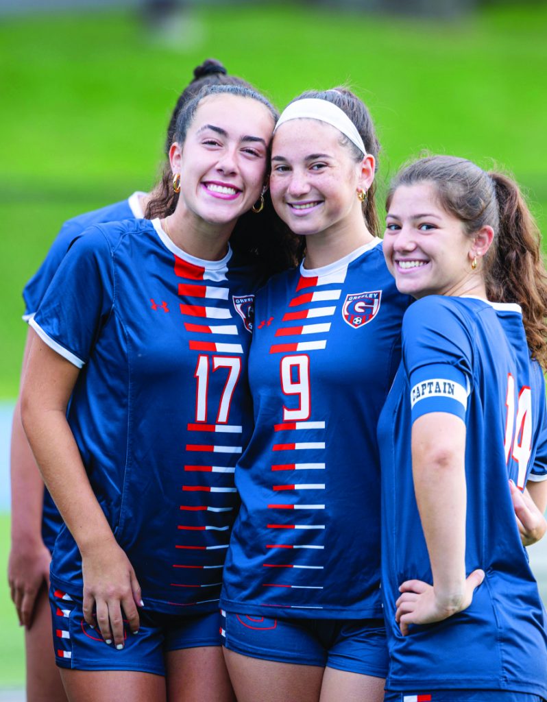 Three members of the girls team pose for the camera.
